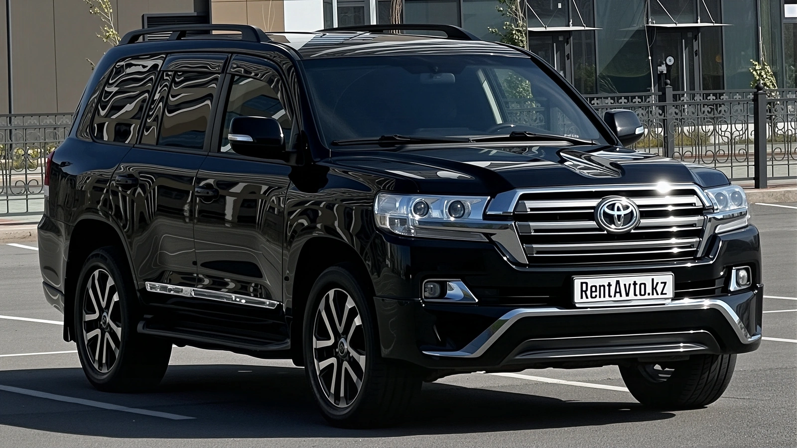 Передний ракурс Toyota Land Cruiser 200, который берут для поездок с водителем по городу