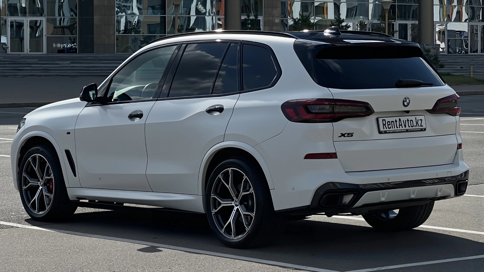Задний ракурс BMW X5M с мощным кузовом, который привлекают для суточной аренды