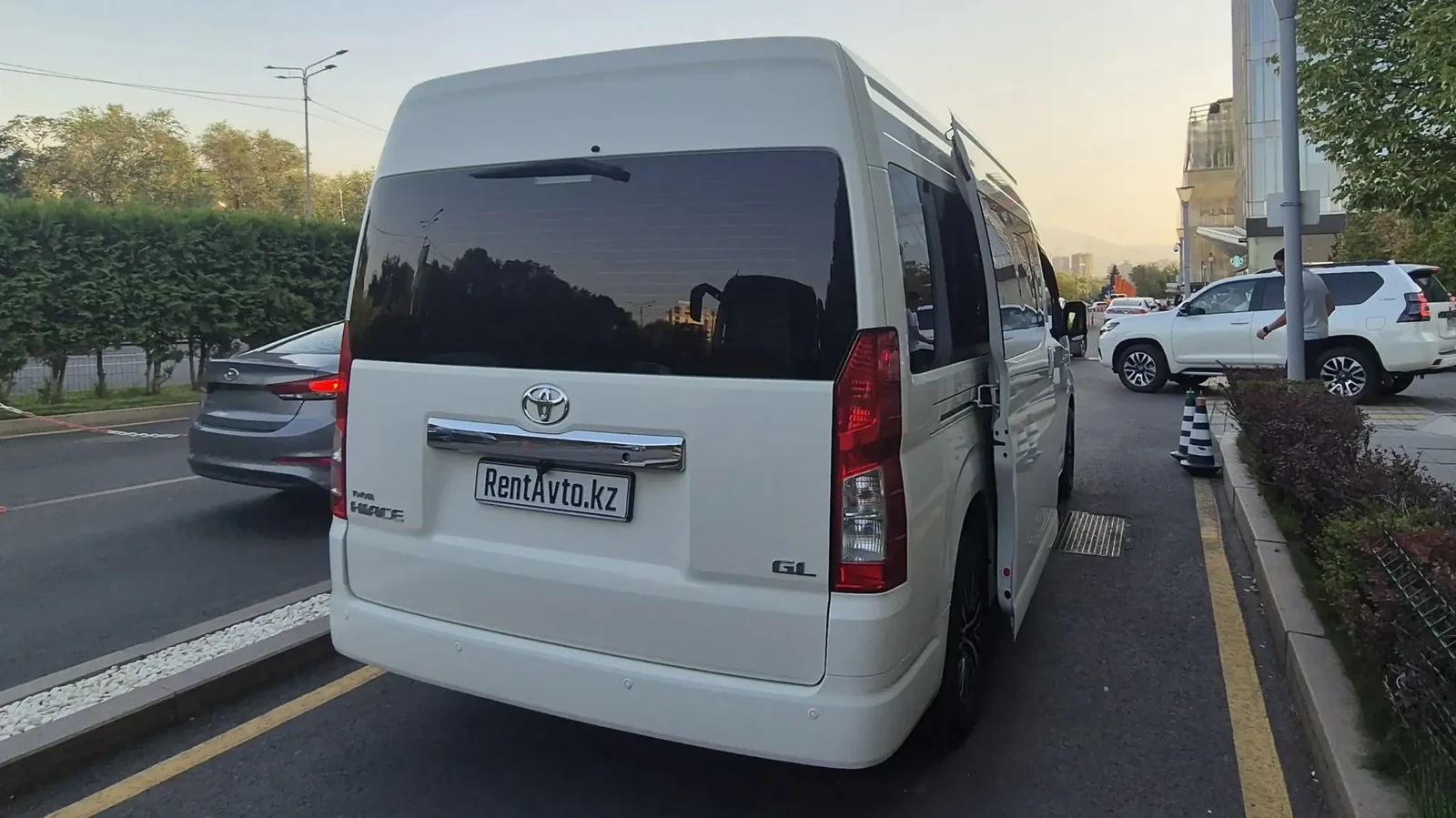 Белый Hiace на 9 мест, припаркованный на дороге перед суточным маршрутом
