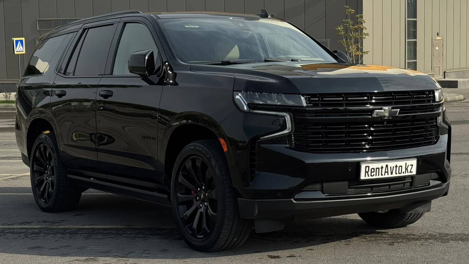 Чёрный Chevrolet Tahoe спереди на парковке, востребованный при аренде с водителем