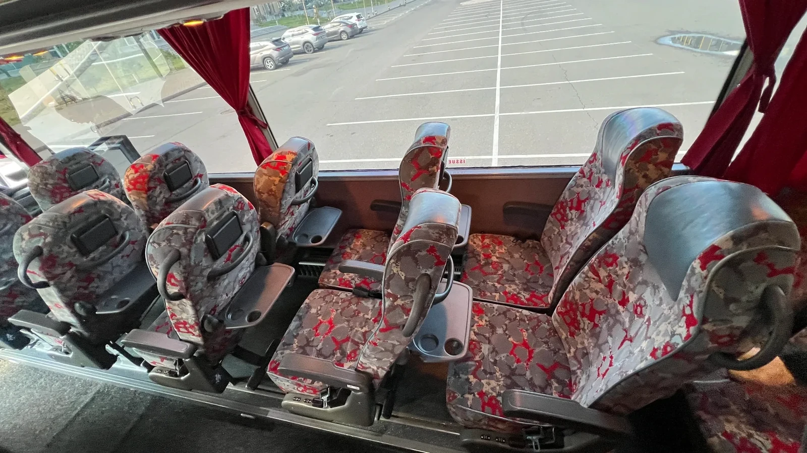 Белый автобус VanHool стоит на городской улице перед выездом на заказ клиентов, заранее запланировавших поездку