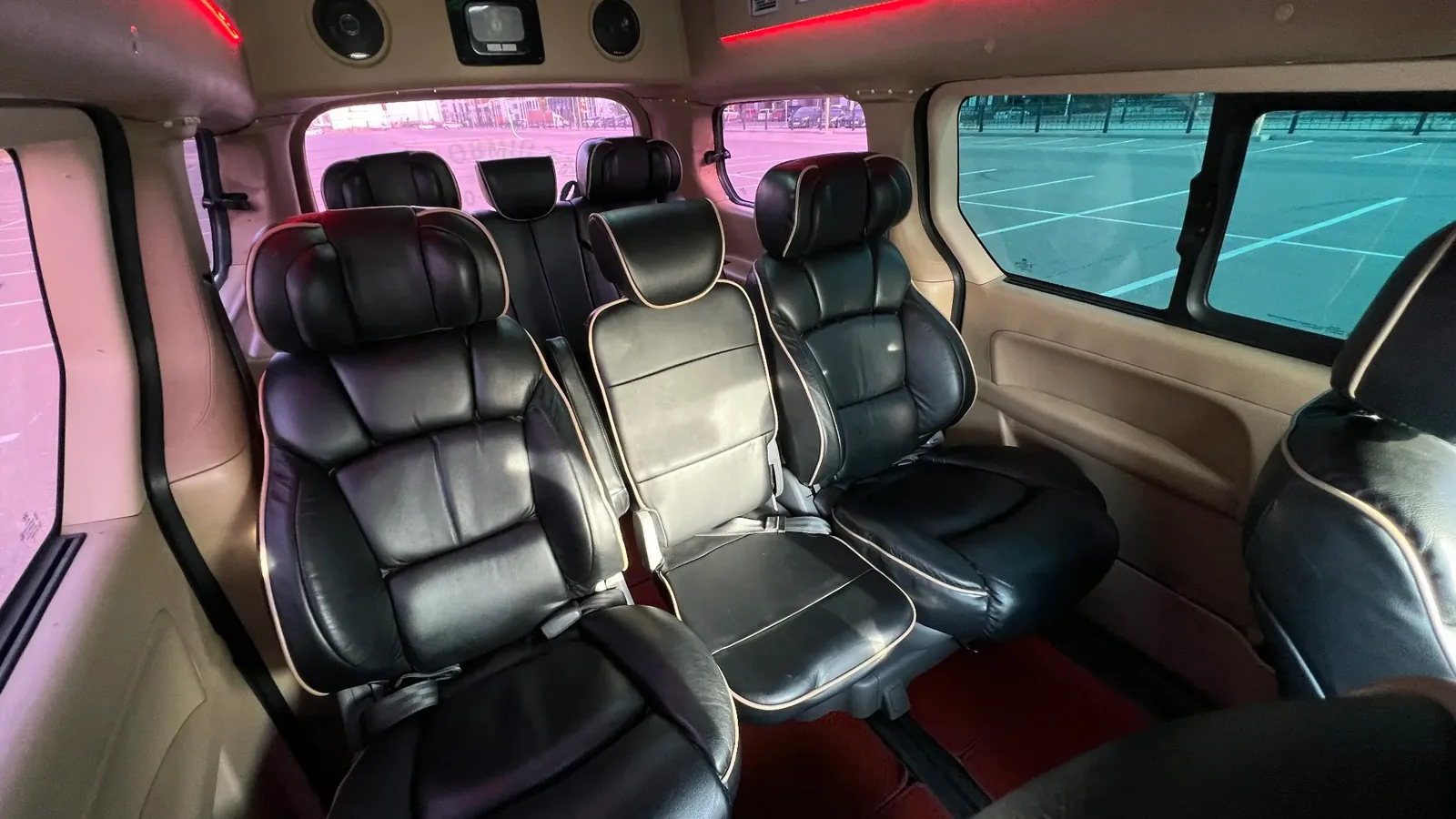 Тёмный минивэн Hyundai Grand Starex VIP стоит у стеклянного фасада офисного здания в Астане