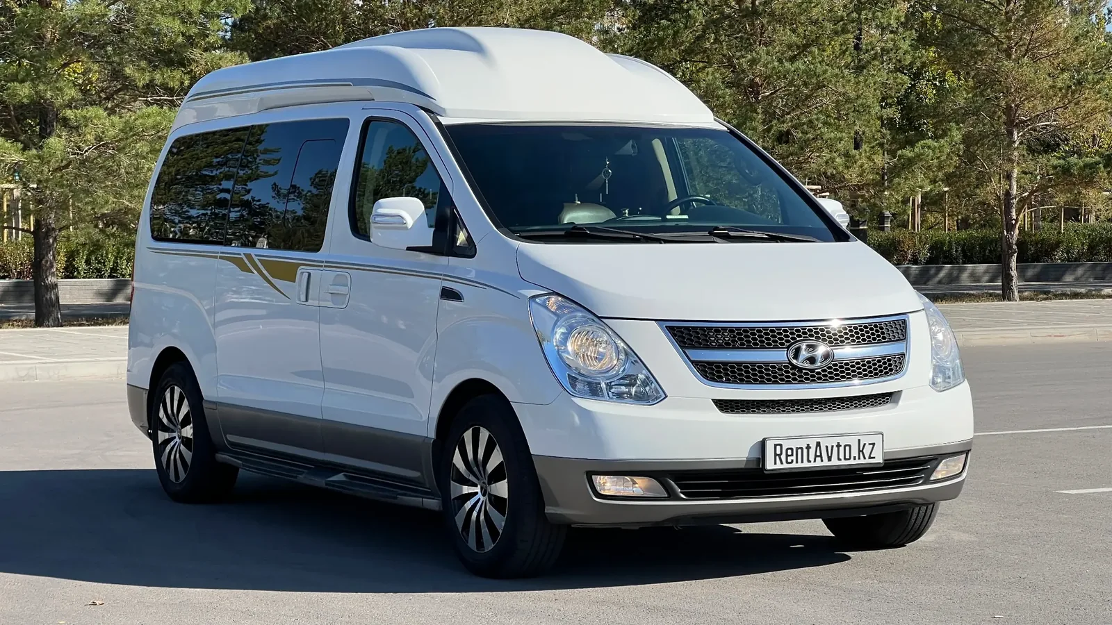 Минивэн Hyundai Grand Starex VIP комплектации припаркован на солнце рядом с невысокими зданиями