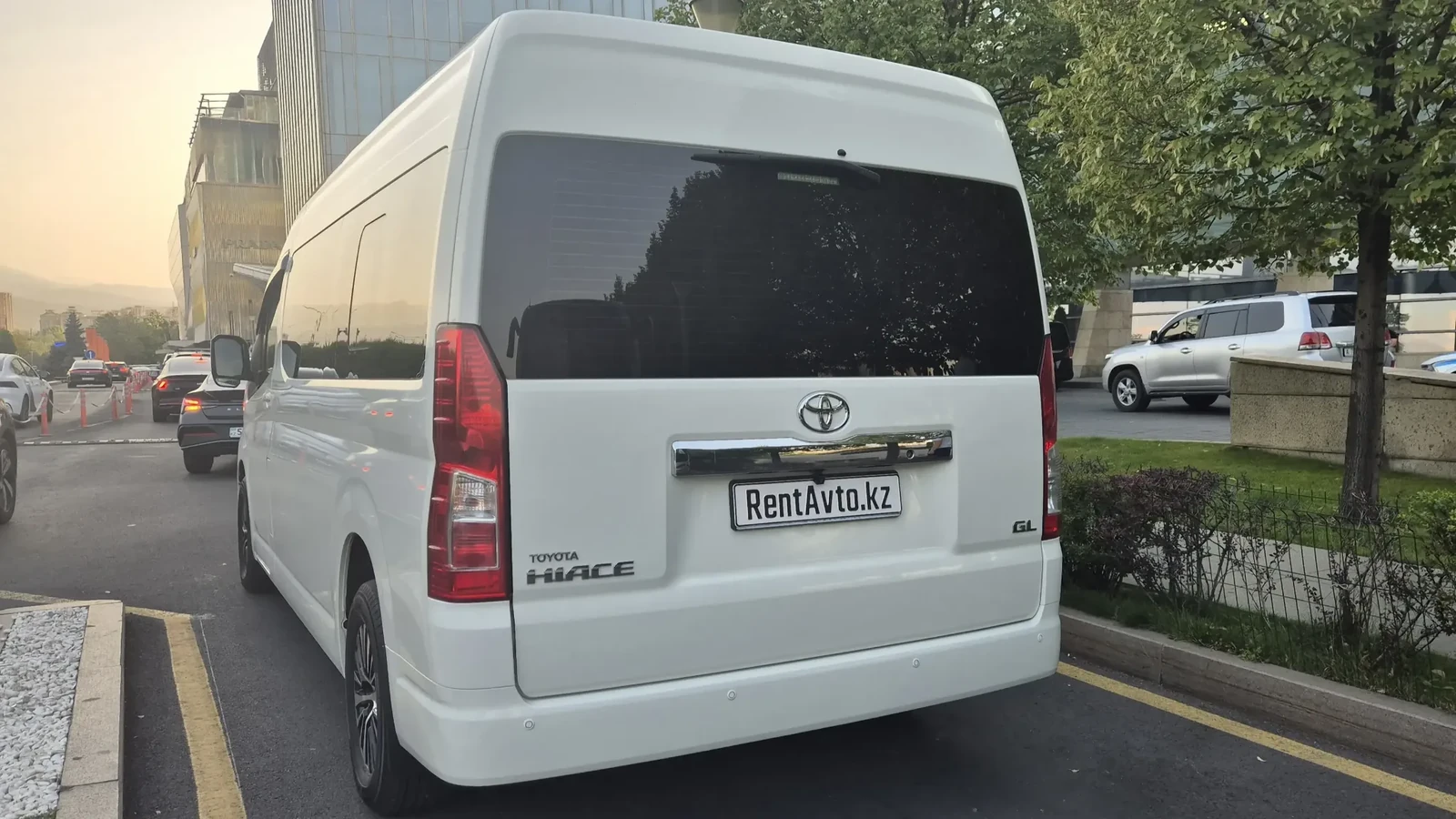Белый Hiace на 9 мест, припаркованный на дороге перед суточным маршрутом